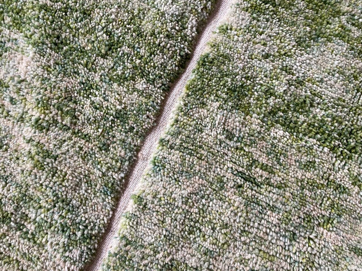 Detail shot of a green rug highlighting its textured design.