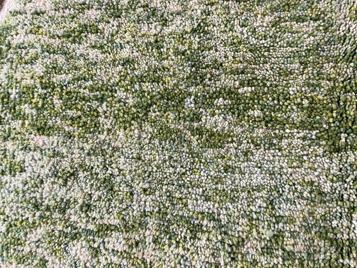 Close-up of the textured surface of a green rug.