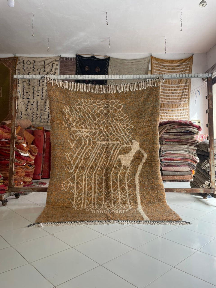 Lifestyle shot of orange and gray Moroccan rug with geometric pattern on natural background.