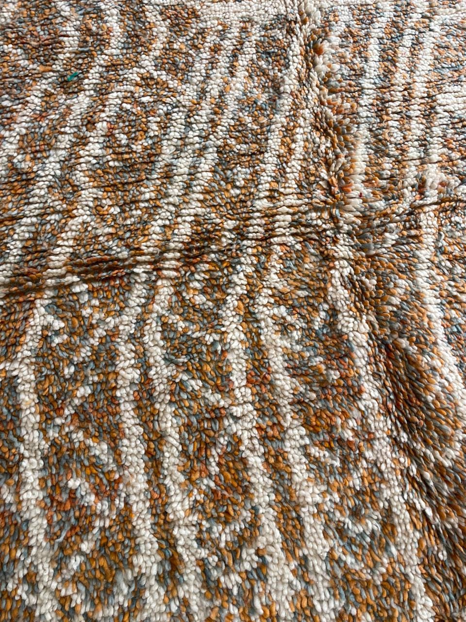 Close-up detail of orange and gray Moroccan rug featuring a geometric design.