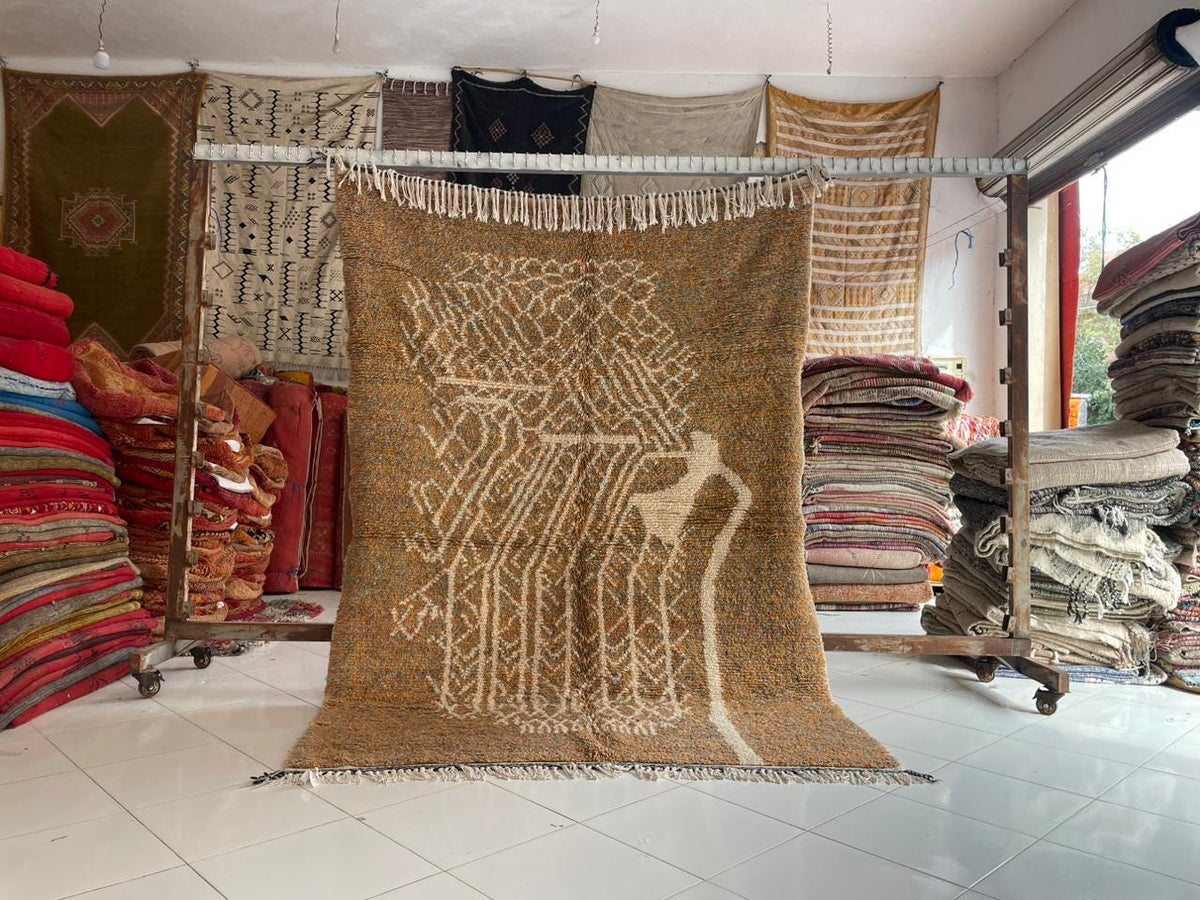 Lifestyle shot of orange and gray Moroccan rug with textured pattern on natural background.