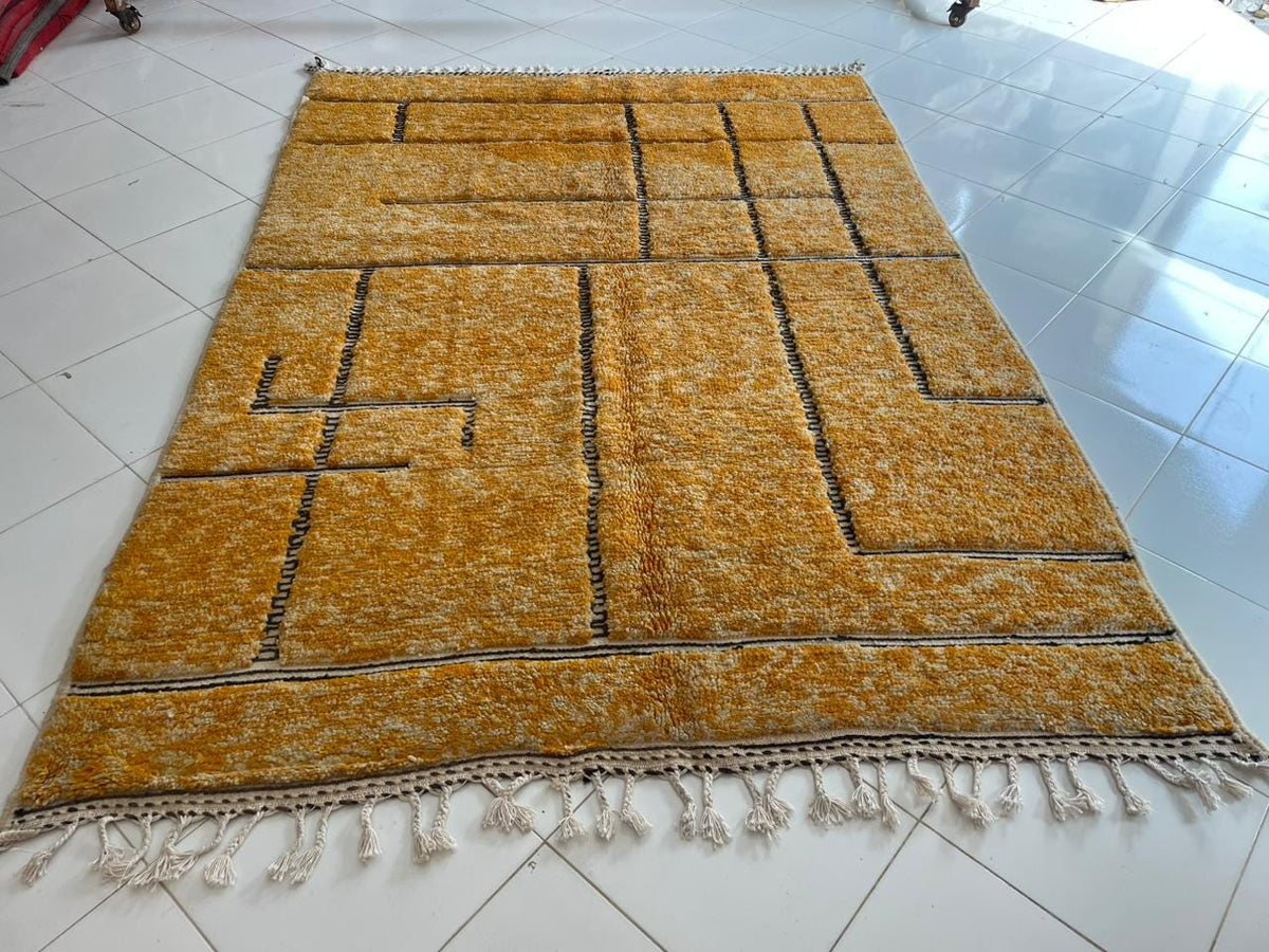 Top view of an orange Moroccan rug showcasing its geometric design.