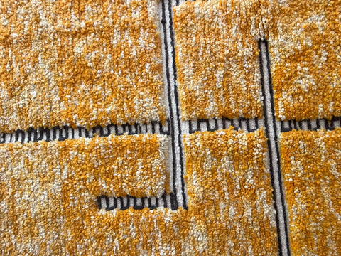 Detail close-up of an orange Moroccan rug featuring a textured pattern.