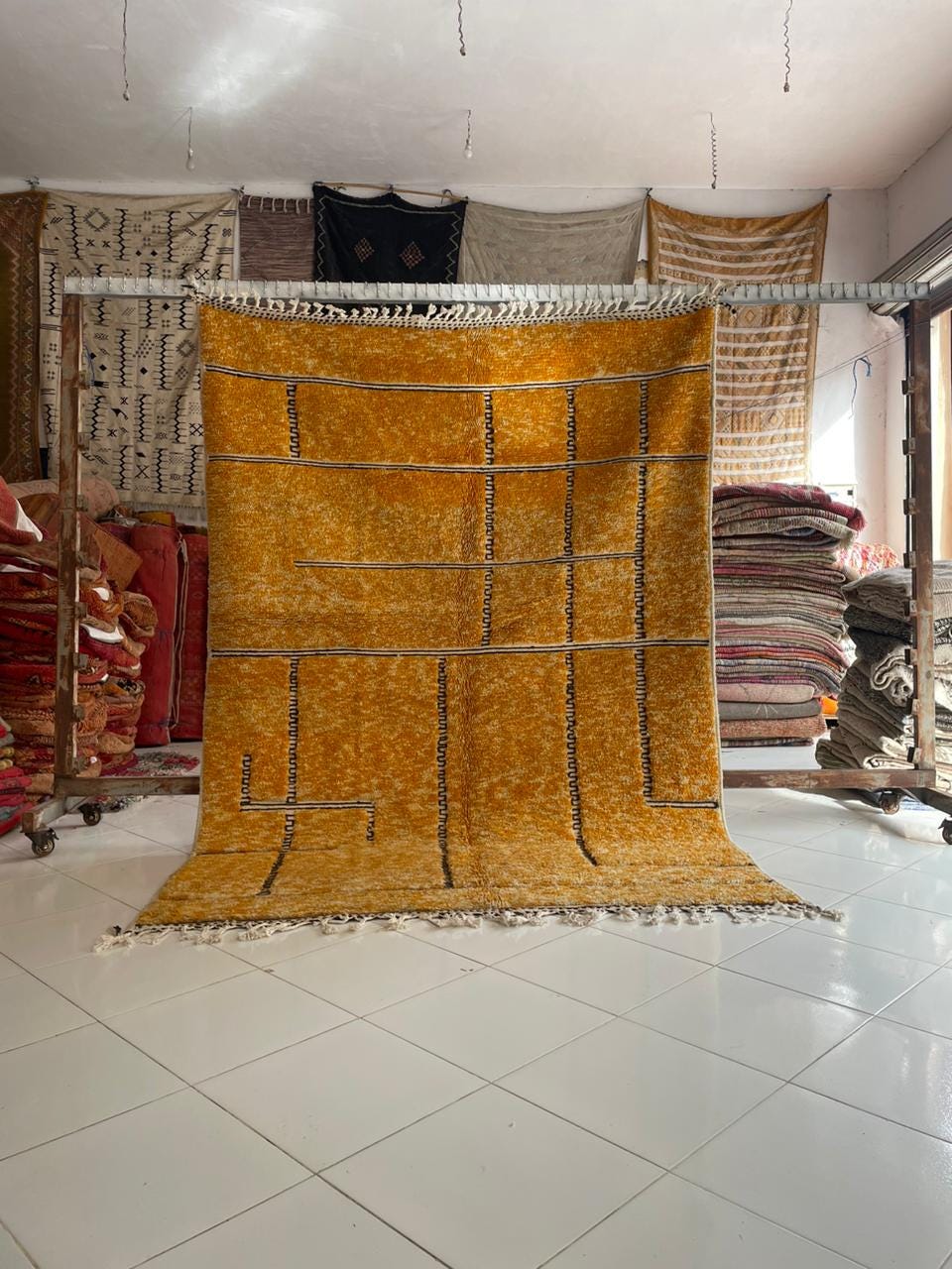 Lifestyle shot of an orange Moroccan rug with a geometric pattern in a natural setting.