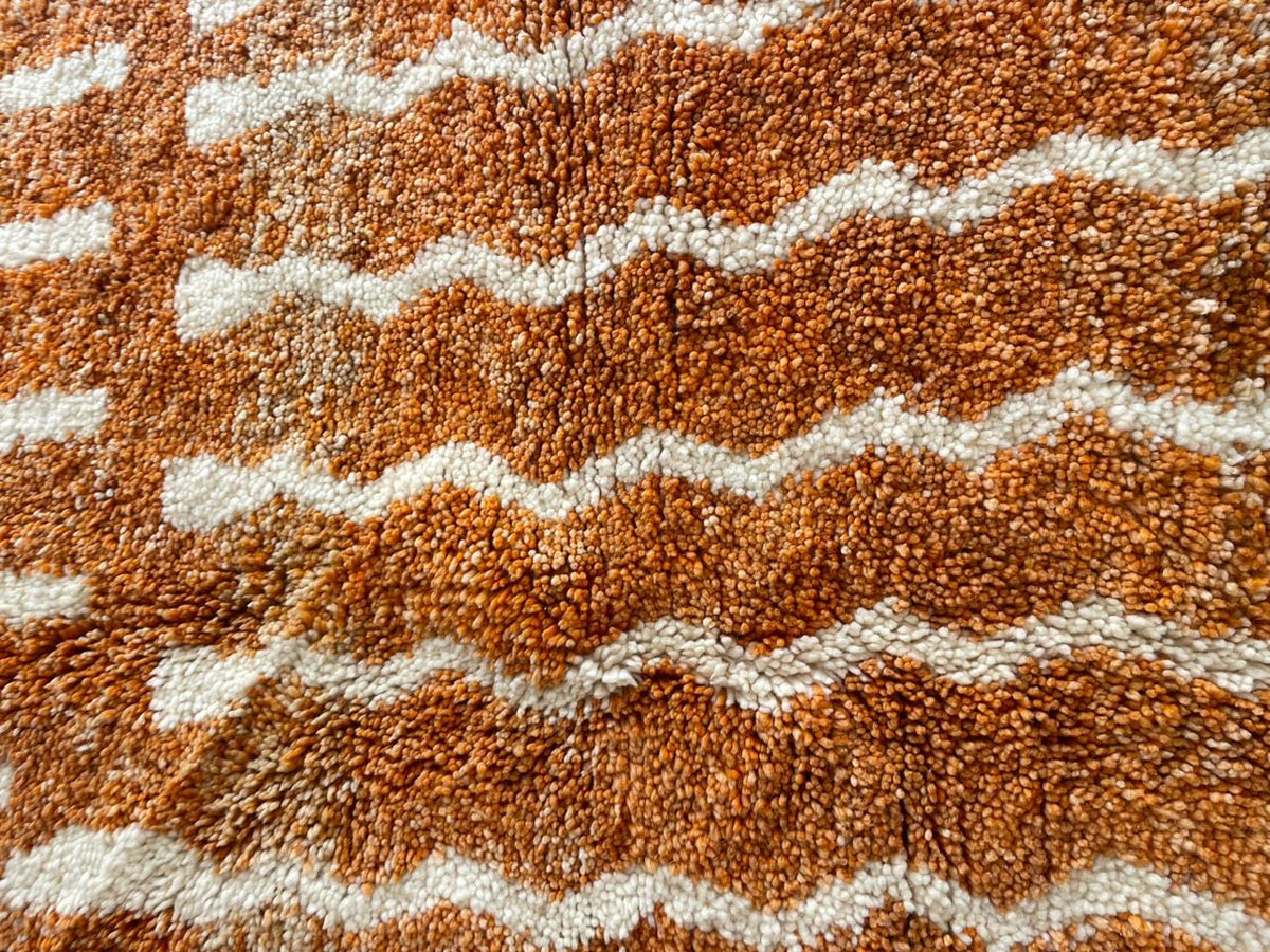 Close-up detail of the orange and white rug featuring a zigzag pattern.