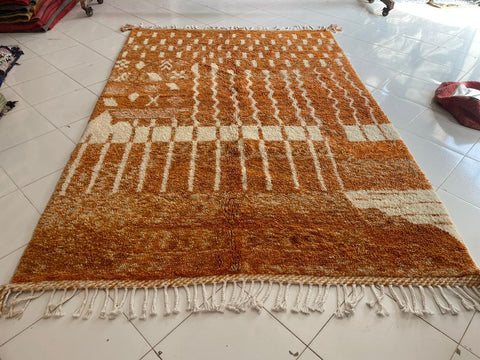 Close-up detail of the orange Moroccan rug showcasing its textured surface.