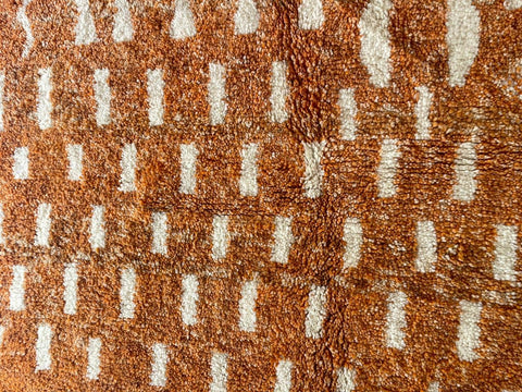Close-up detail of the orange and white rug showcasing a striped pattern.