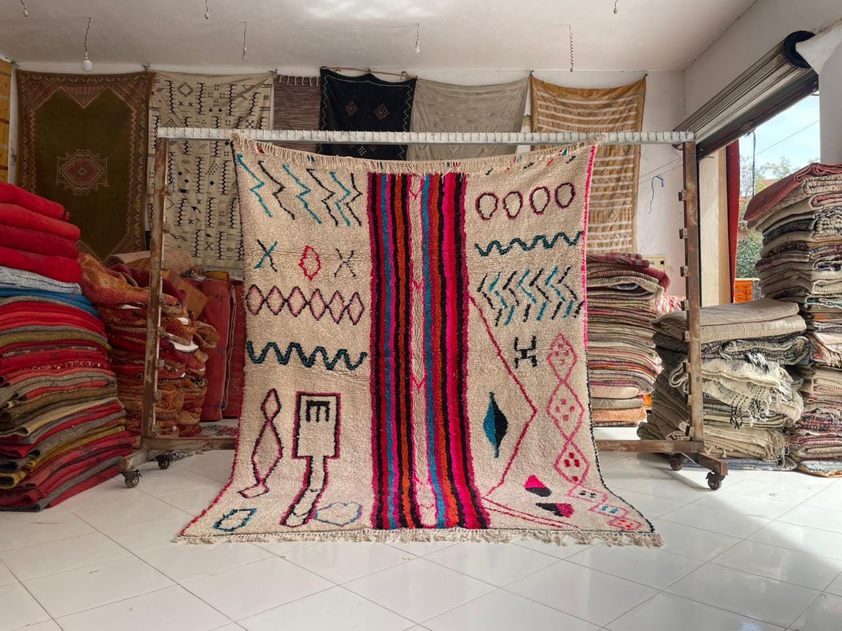 Lifestyle shot of hanging colorful rugs with varied patterns in a natural setting.