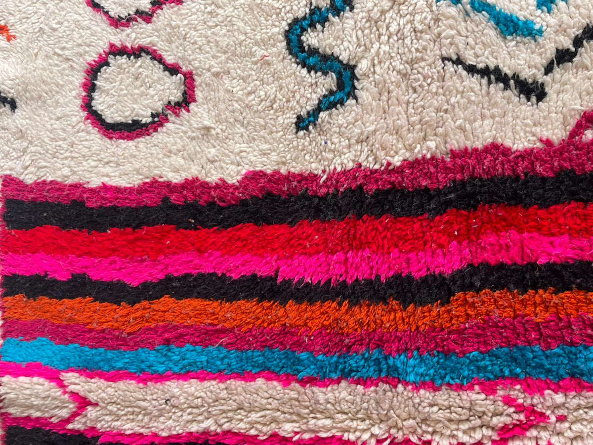 Close-up detail of a vibrant pink Moroccan rug with a textured pattern.