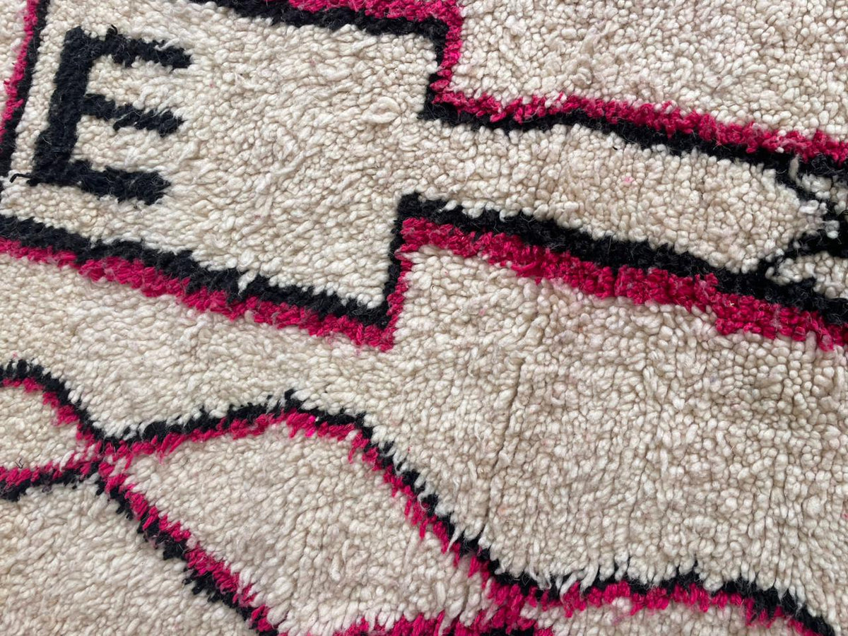 Close-up detail of the pink Moroccan rug featuring abstract patterns and soft texture.