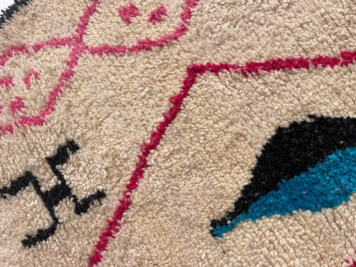 Close-up detail of a colorful pink Moroccan rug with a geometric design.