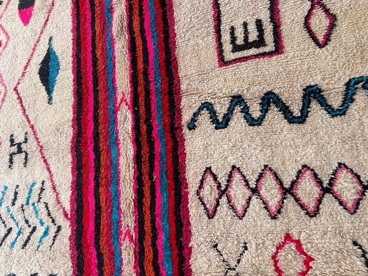 Close-up detail of the pink Moroccan rug's texture and geometric patterns.