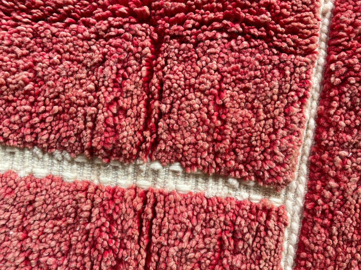 Close-up of a red Moroccan rug with a textured pattern.