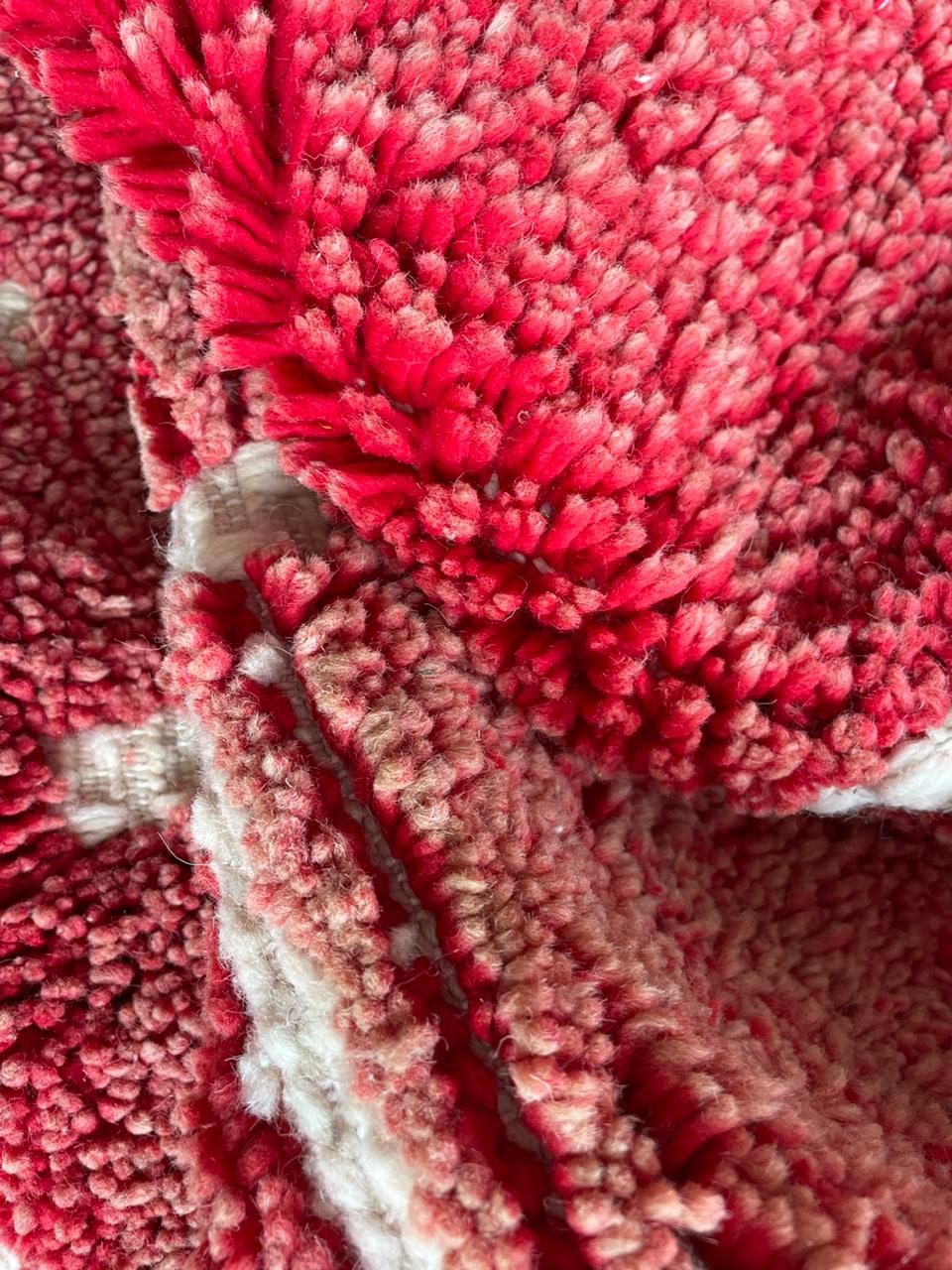 Close-up detail of a red Moroccan rug showcasing its textured pattern.