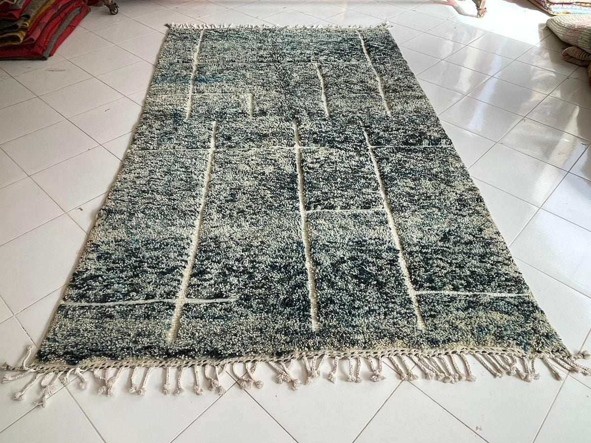 Detail close-up of a turquoise Moroccan rug showcasing fringe edges.