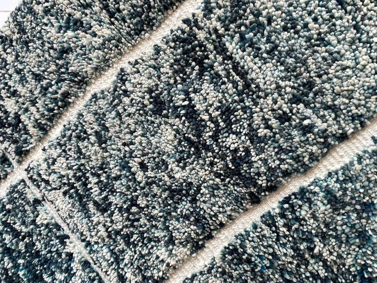 Detail close-up of a textured surface on a turquoise Moroccan rug.