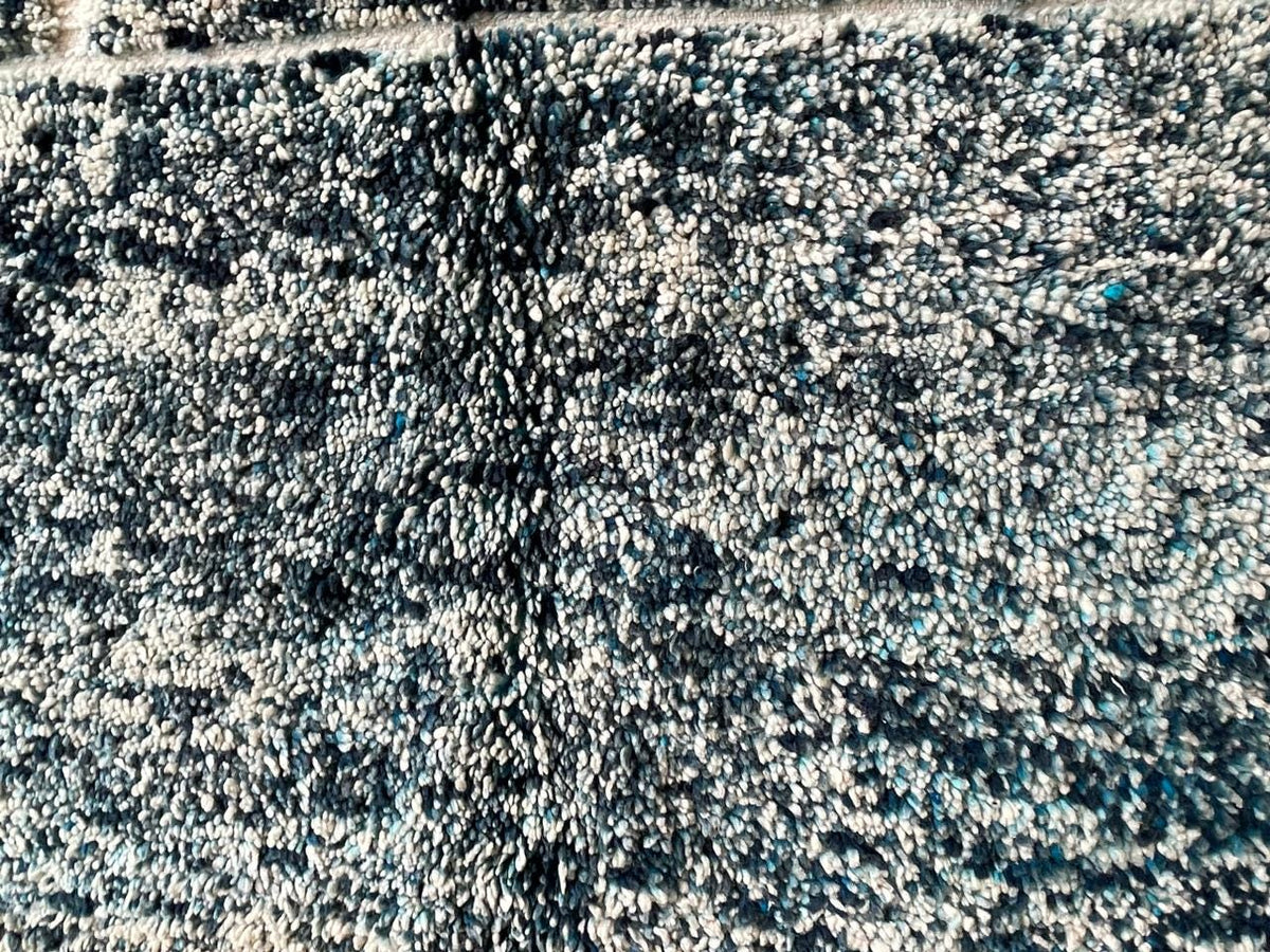 Detail close-up of a bohemian-style turquoise rug with black accents.