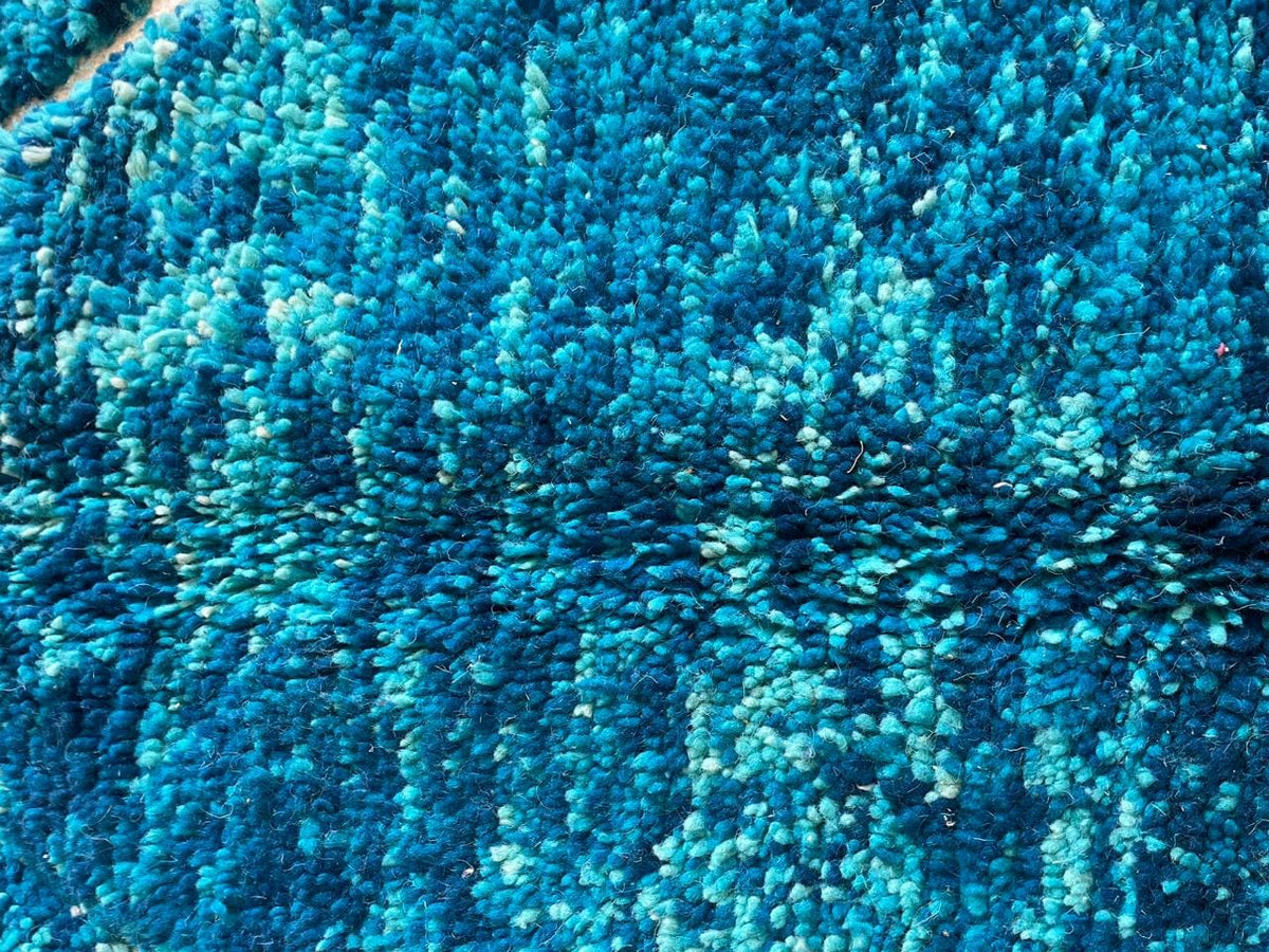 Detail shot highlighting the textured surface of the turquoise Beni Ourain Moroccan rug.