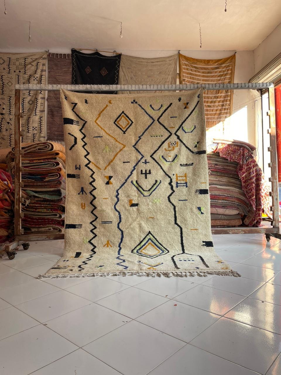 Lifestyle shot of a white Moroccan rug with geometric patterns in a natural setting.