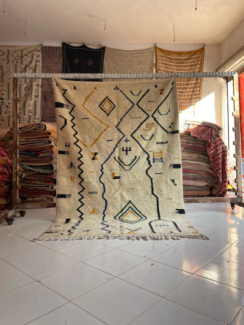 Lifestyle shot of a white Moroccan rug with geometric patterns in a natural setting.