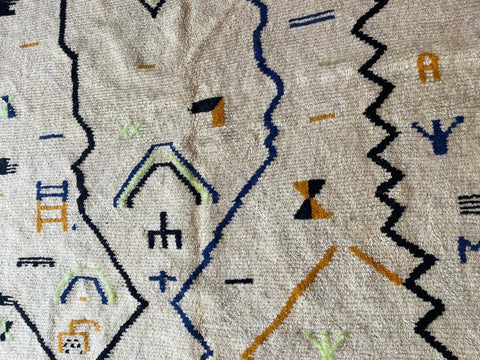 Detail close-up of a white Moroccan rug showcasing geometric patterns on a solid background.