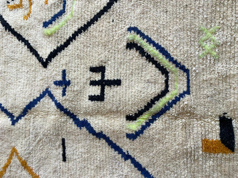 Detail close-up of a white Moroccan rug highlighting geometric patterns on a solid background.