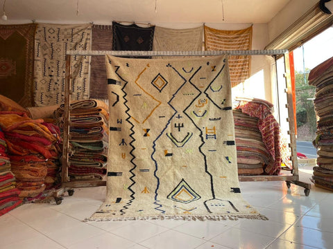 Lifestyle shot of a white Moroccan rug featuring an abstract design in a natural setting.