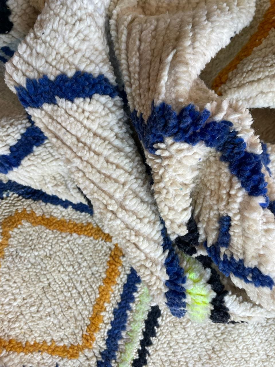 Detail shot of a white Moroccan rug showcasing geometric patterns and a textured appearance.