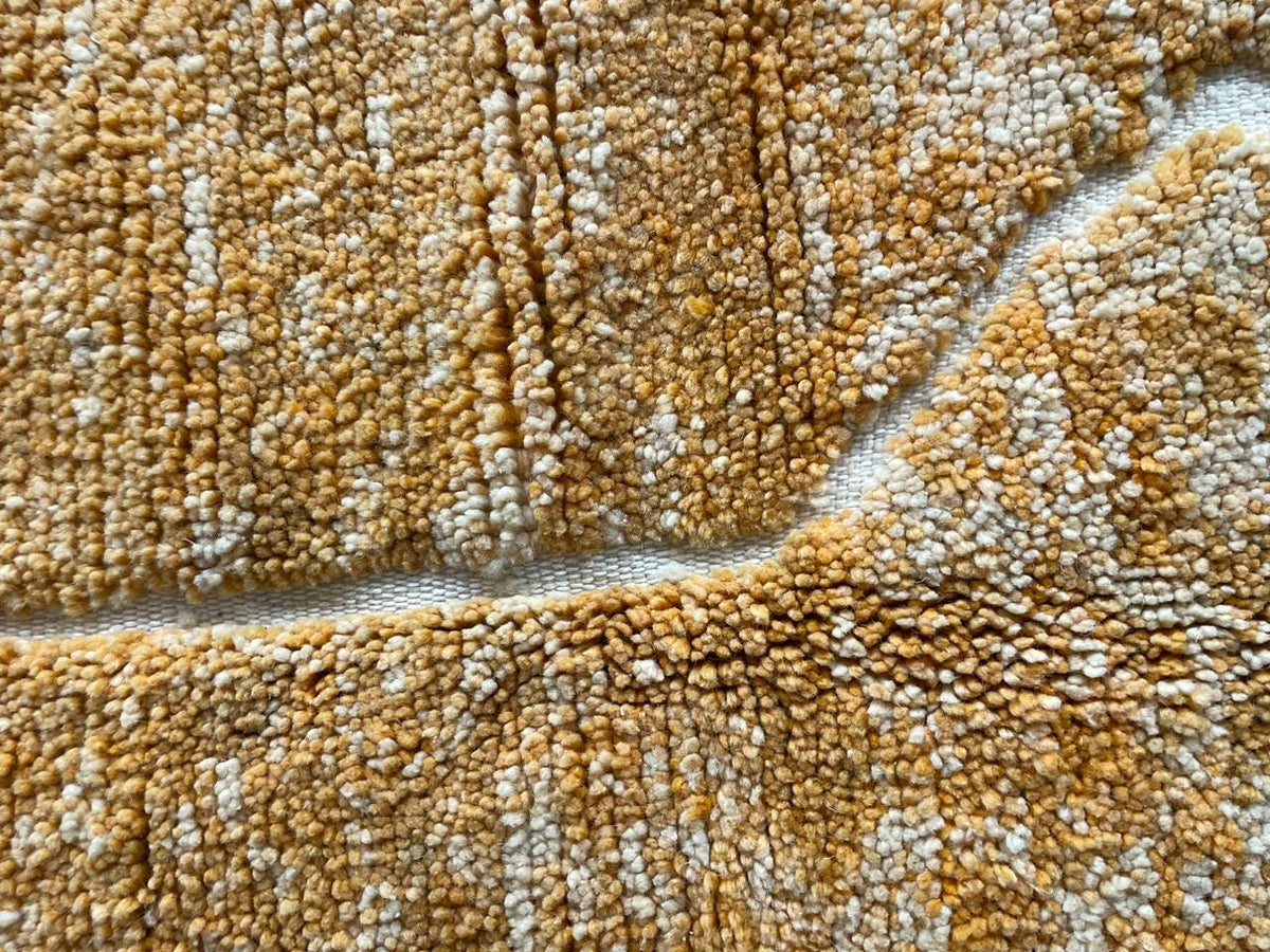 Detail shot of a yellow Moroccan rug highlighting its textured surface.