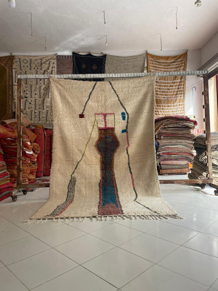 Lifestyle shot of a colorful Moroccan rug featuring geometric patterns and fringe edges.