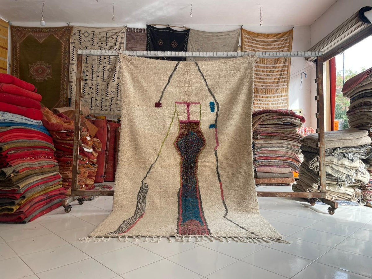 Lifestyle shot of a colorful Moroccan rug with geometric patterns and fringed edges.