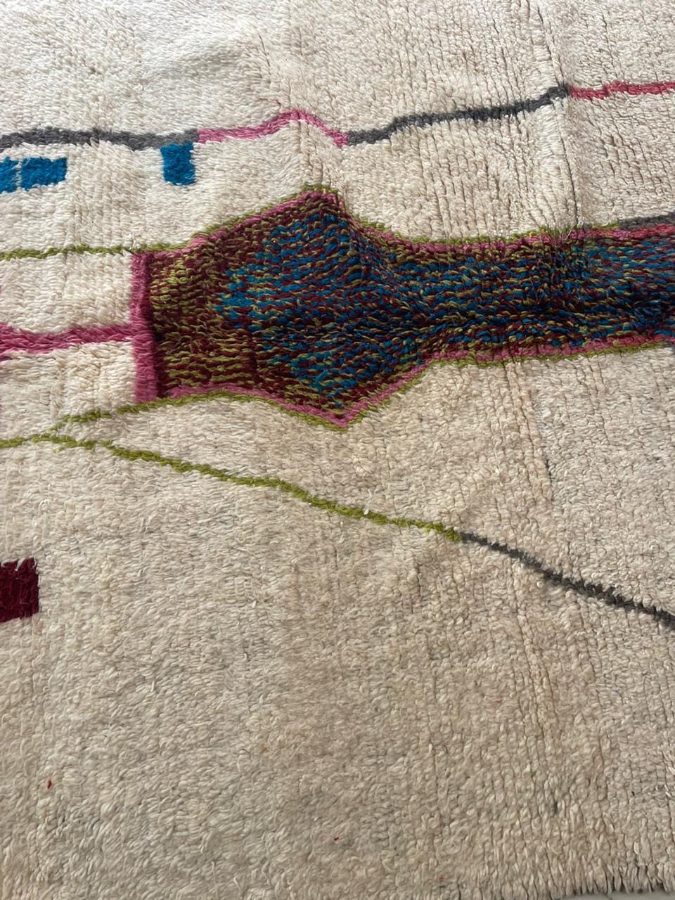 Close-up detail of a colorful Moroccan rug highlighting geometric patterns and fringe edges.