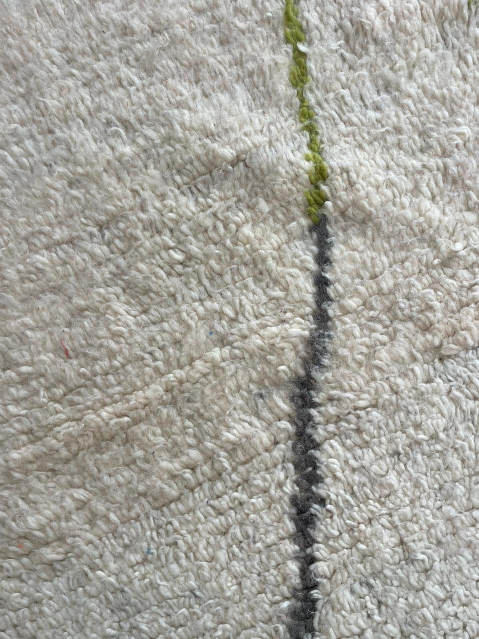 Close-up of a textured surface of a colorful Moroccan rug with subtle patterns.