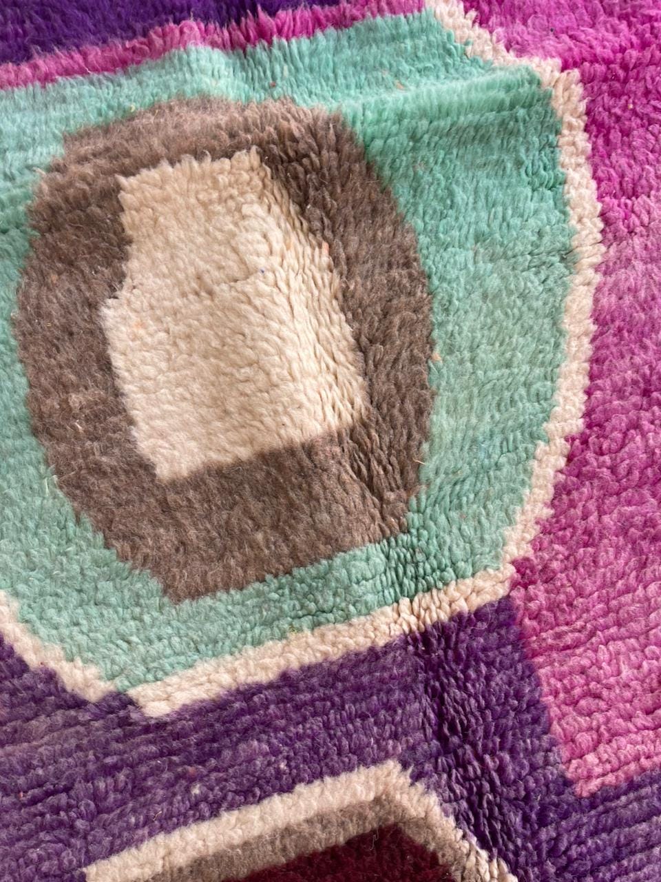 Close-up detail of a purple Moroccan rug with geometric shapes and a soft texture.