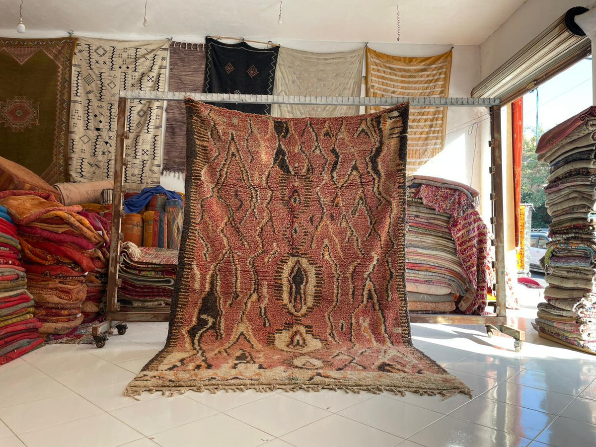 Lifestyle shot of a vintage Moroccan rug displaying intricate designs in multiple colors.