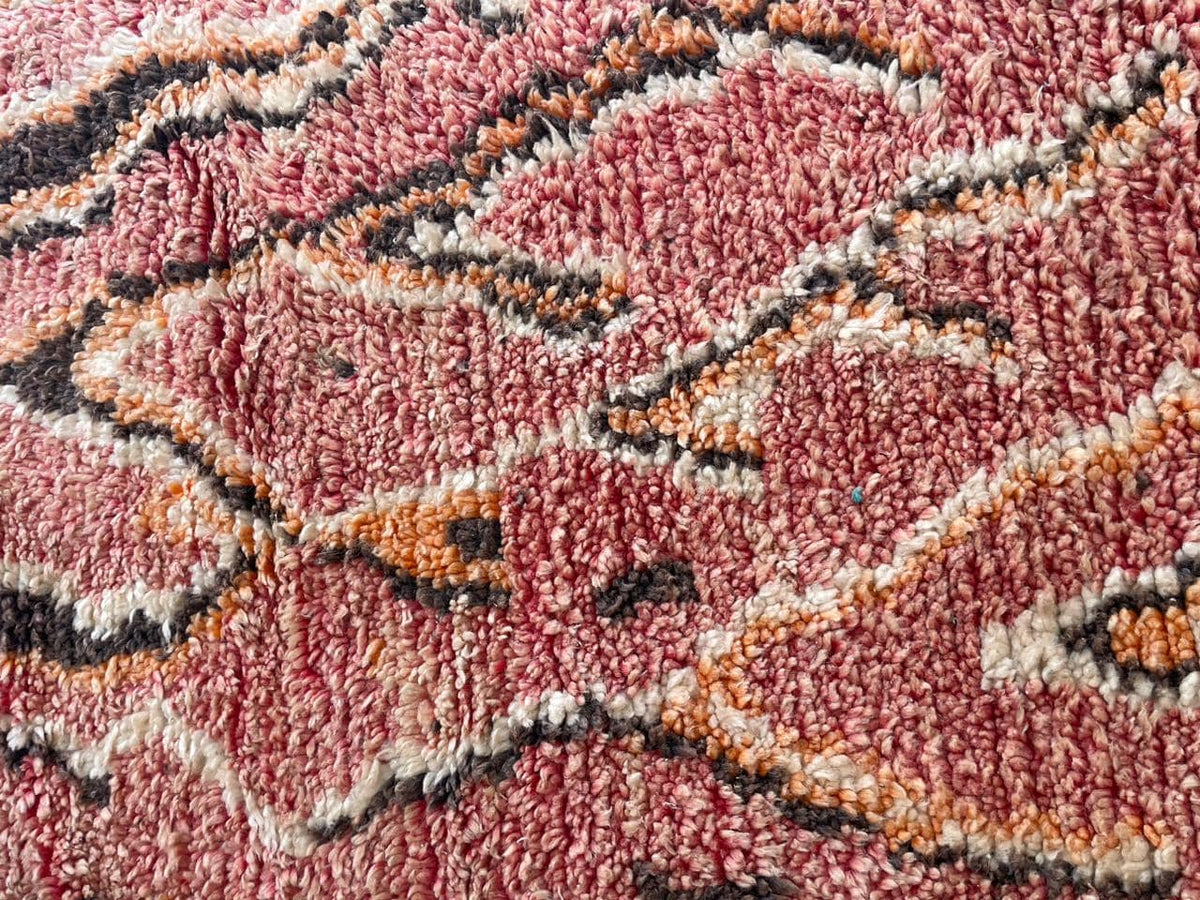 Close-up detail of a vintage Moroccan rug showcasing its tribal pattern and rich colors.