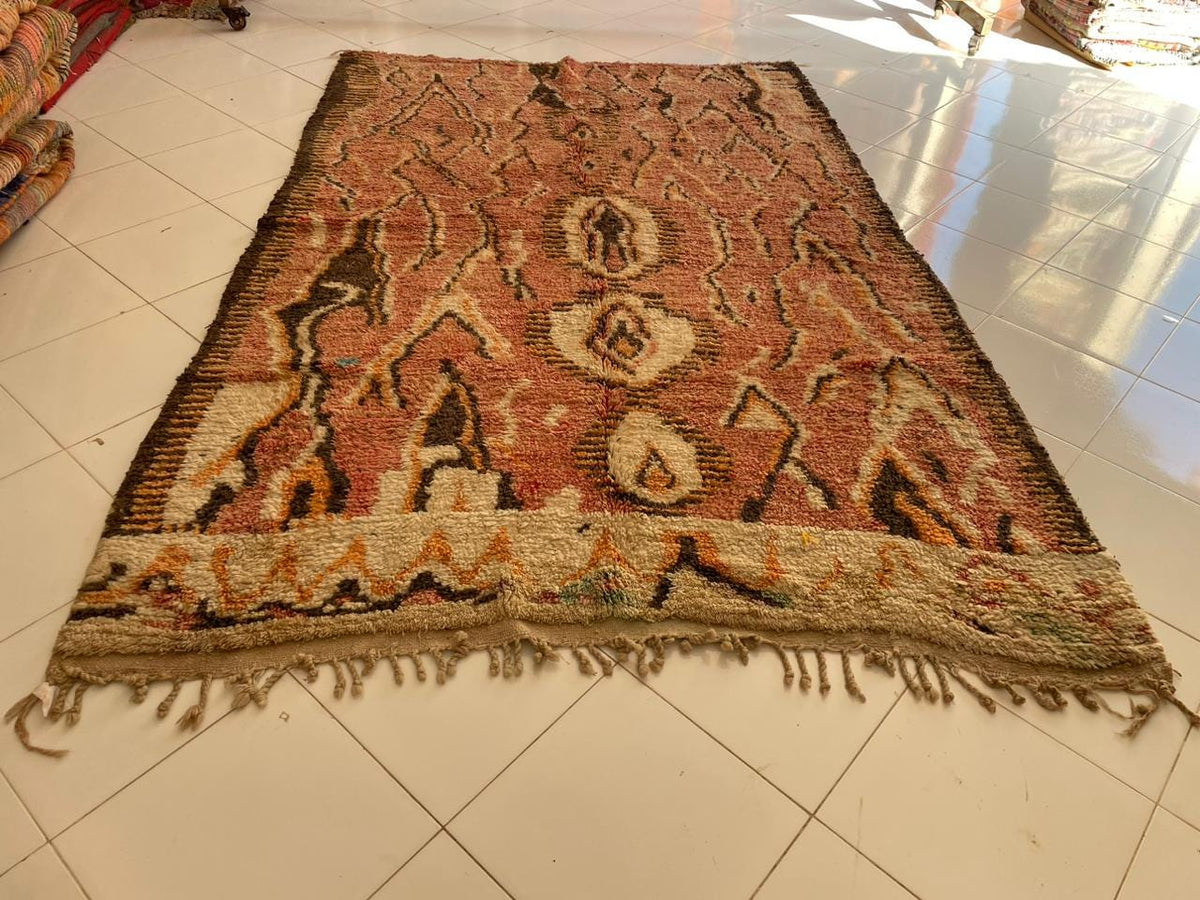 Front view of a vintage Moroccan rug showcasing its fringed edges and intricate design.