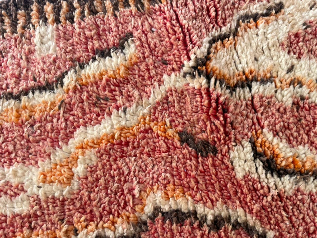 Detail shot of a vintage Moroccan rug emphasizing its tribal pattern and handmade features.