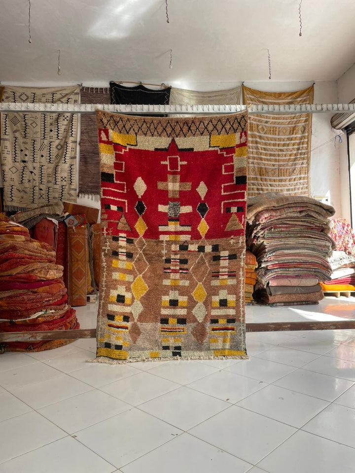 Lifestyle shot of a colorful Moroccan rug with tribal patterns in a natural setting.