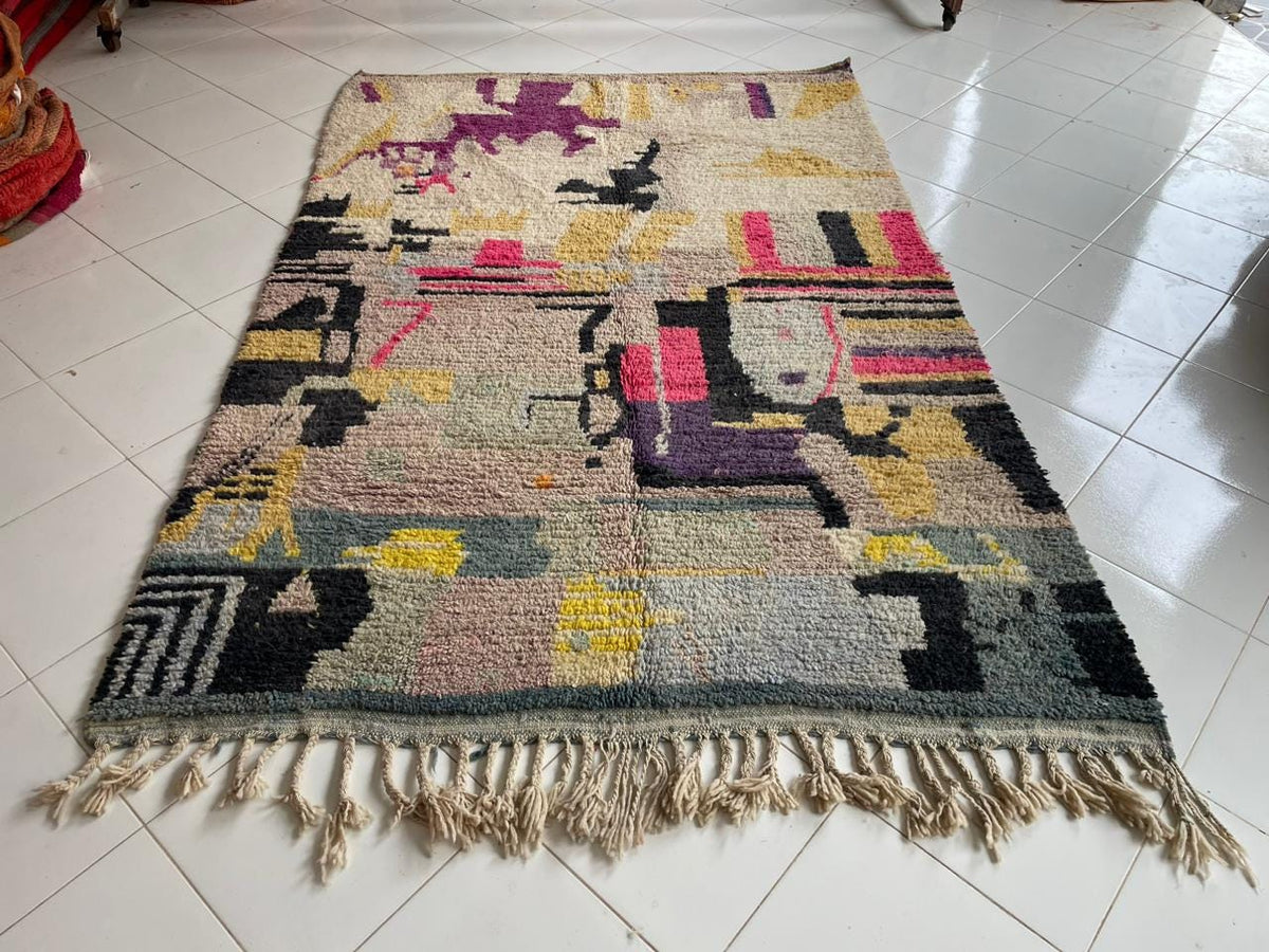 Detail close-up of the abstract design and textured surface of the rug in yellow, pink, and black.