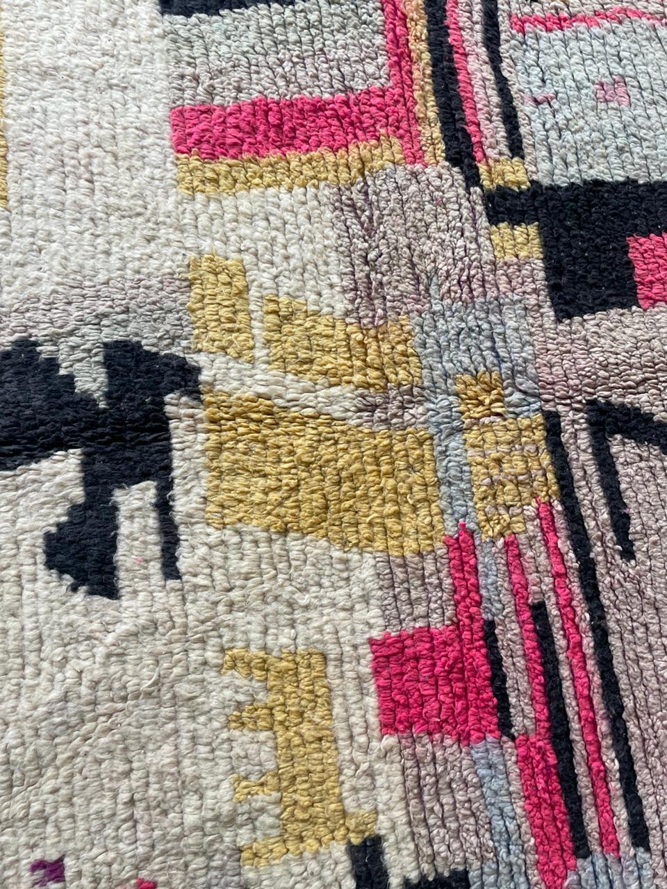 Detail of the rug pattern featuring abstract design in yellow, pink, and white colors.