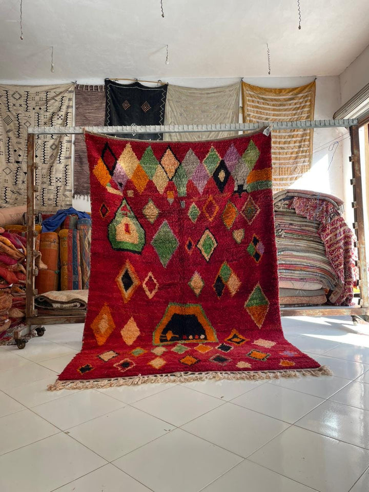 Lifestyle shot of a colorful Moroccan rug featuring geometric patterns in a natural setting.