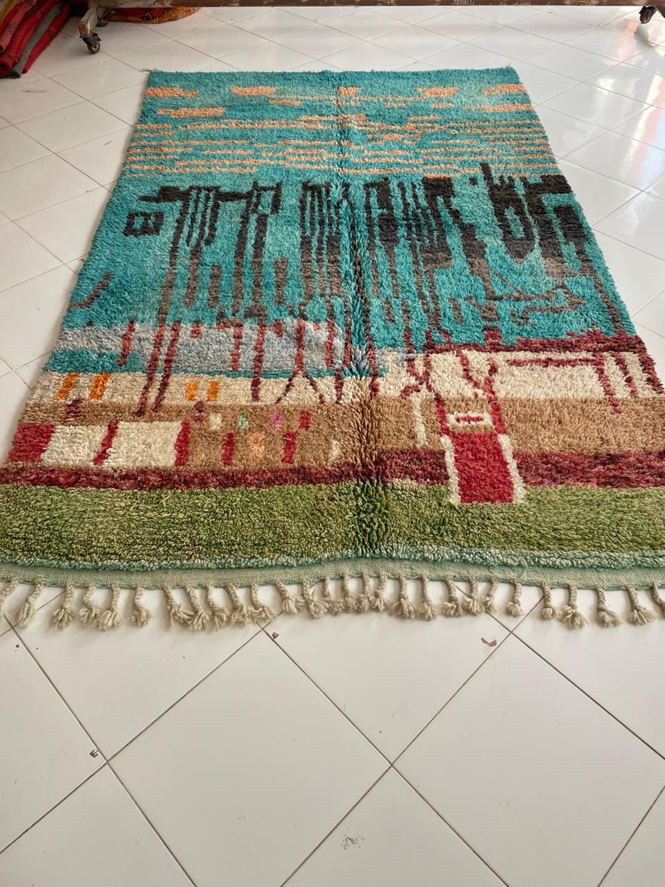 Close-up of a colorful rug with a textured surface in turquoise and orange.