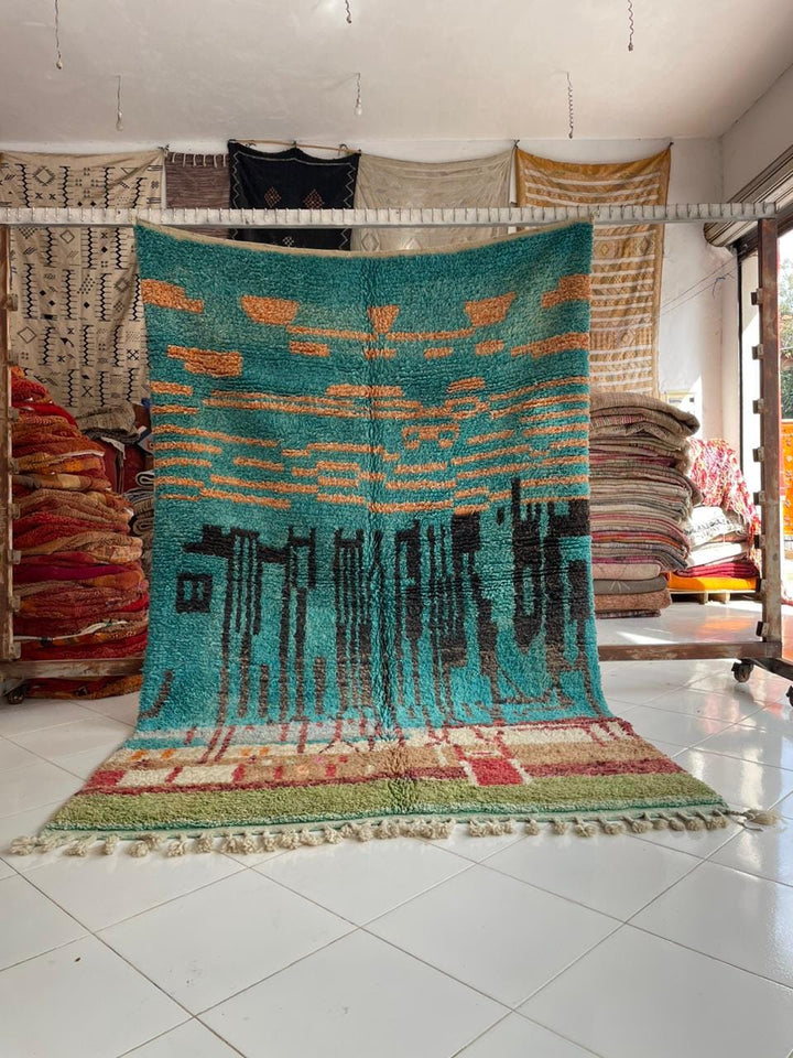 Lifestyle shot of a colorful Moroccan rug with geometric patterns in blue, orange, and green.