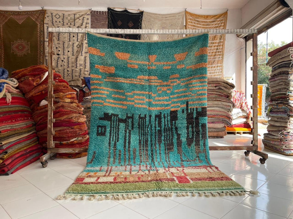 Lifestyle shot of a large area rug with vibrant patterns in blue, orange, and green.