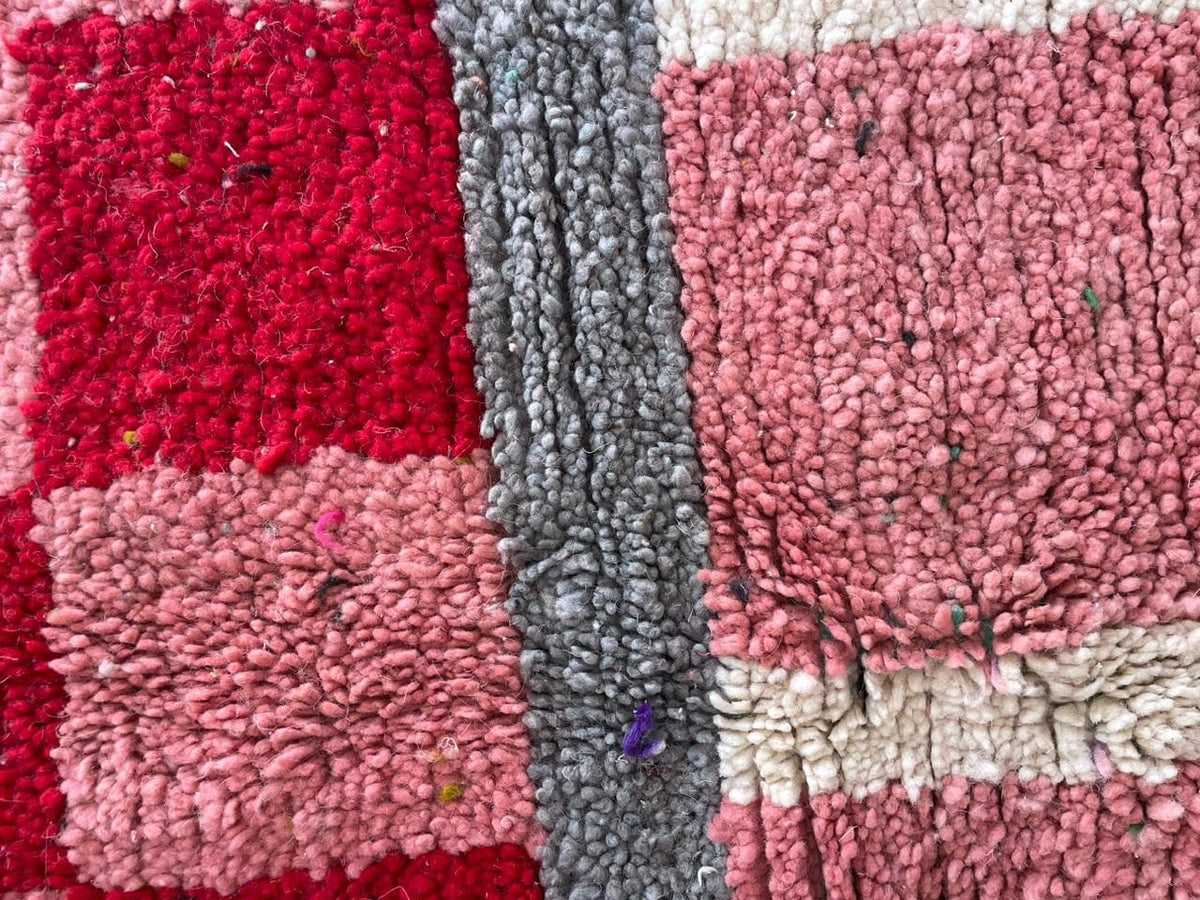 Close-up detail of a textured pattern on the pink Moroccan rug with tribal design.