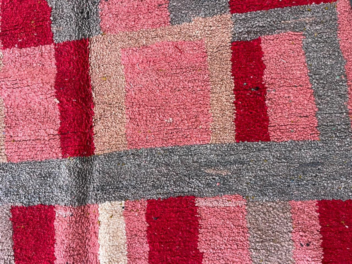 Close-up detail of a textured pattern on the pink Moroccan rug with tribal design.