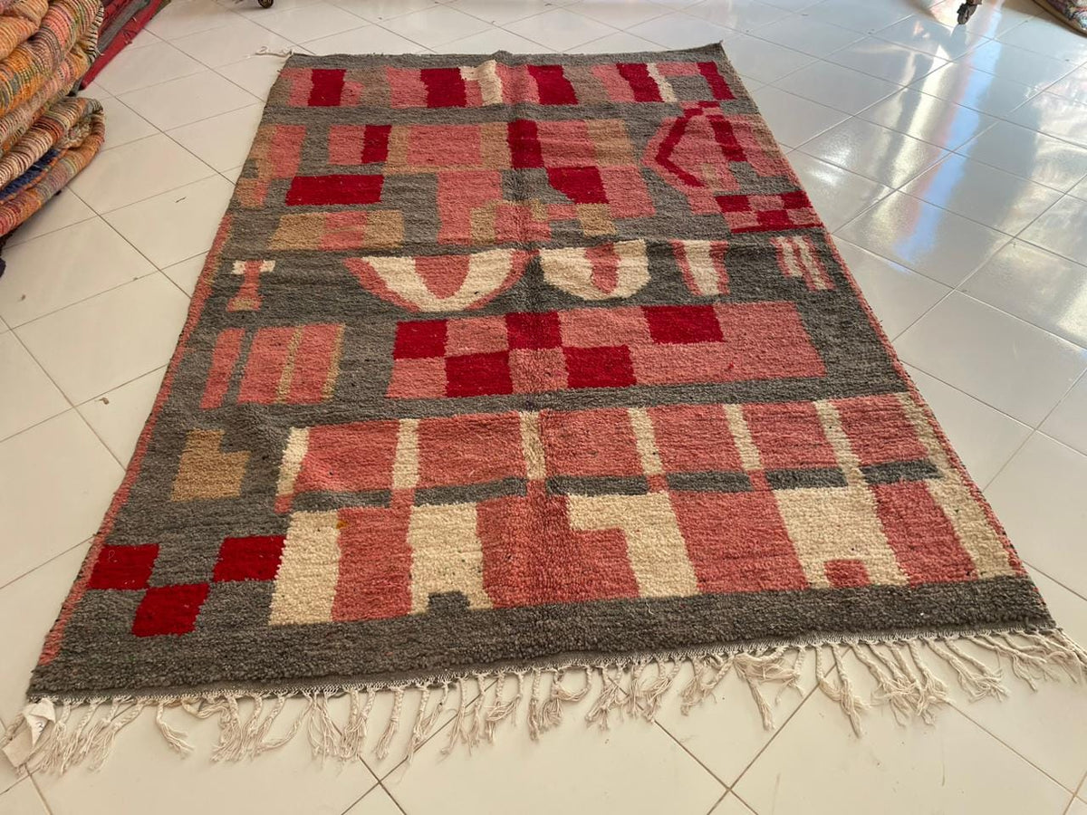 Close-up detail of the pink Moroccan rug showcasing fringe edges and tribal patterns.