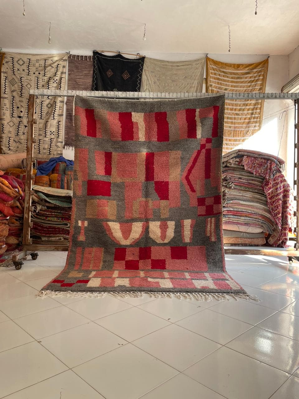 Lifestyle shot of a pink vintage Moroccan rug with tribal patterns in a natural setting.