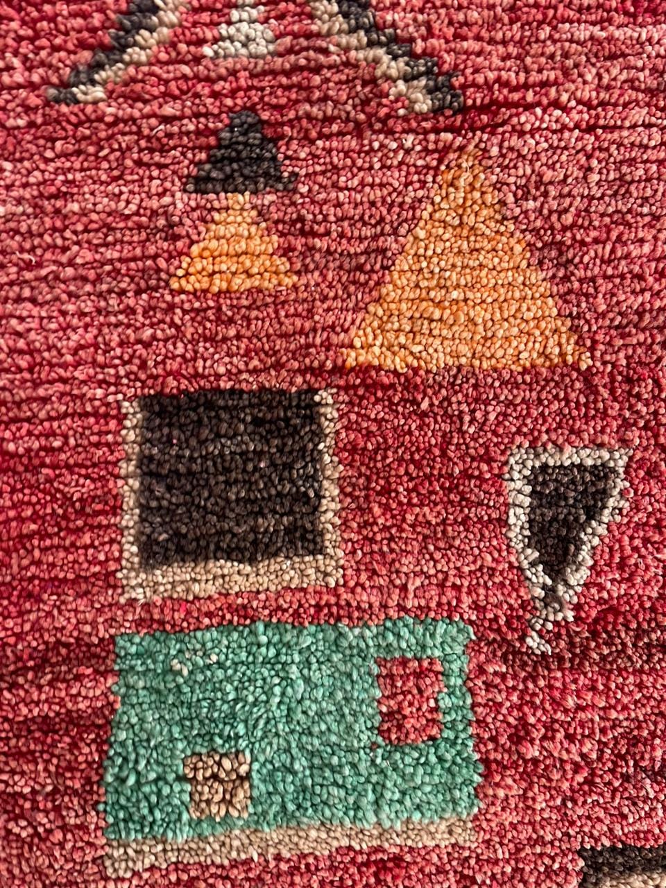 Detail shot highlighting geometric shapes and colorful designs on the red Moroccan rug.